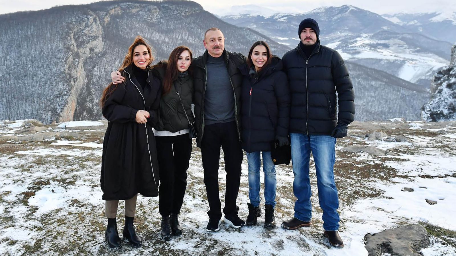 The Aliyev family in front of a snowy mountain landscape in Shusha, 2021