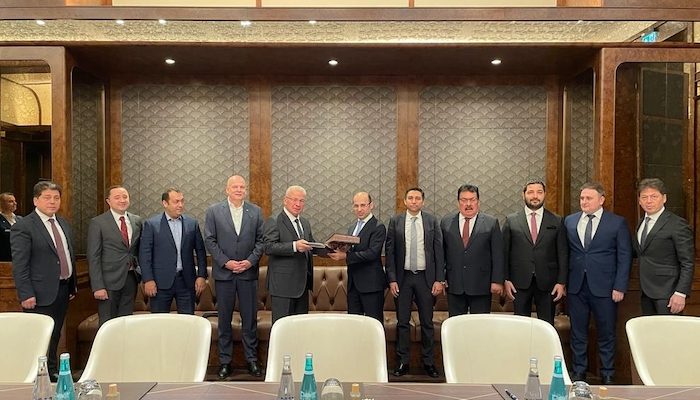 Executives standing side by side in a room in the partnership announcement photograph